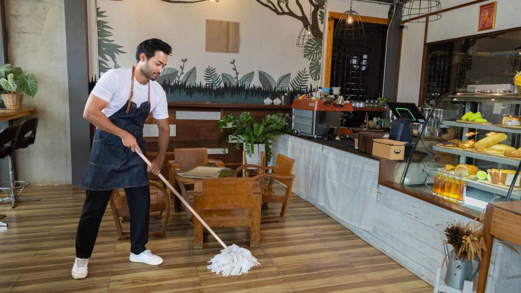 A man mopping his cafe